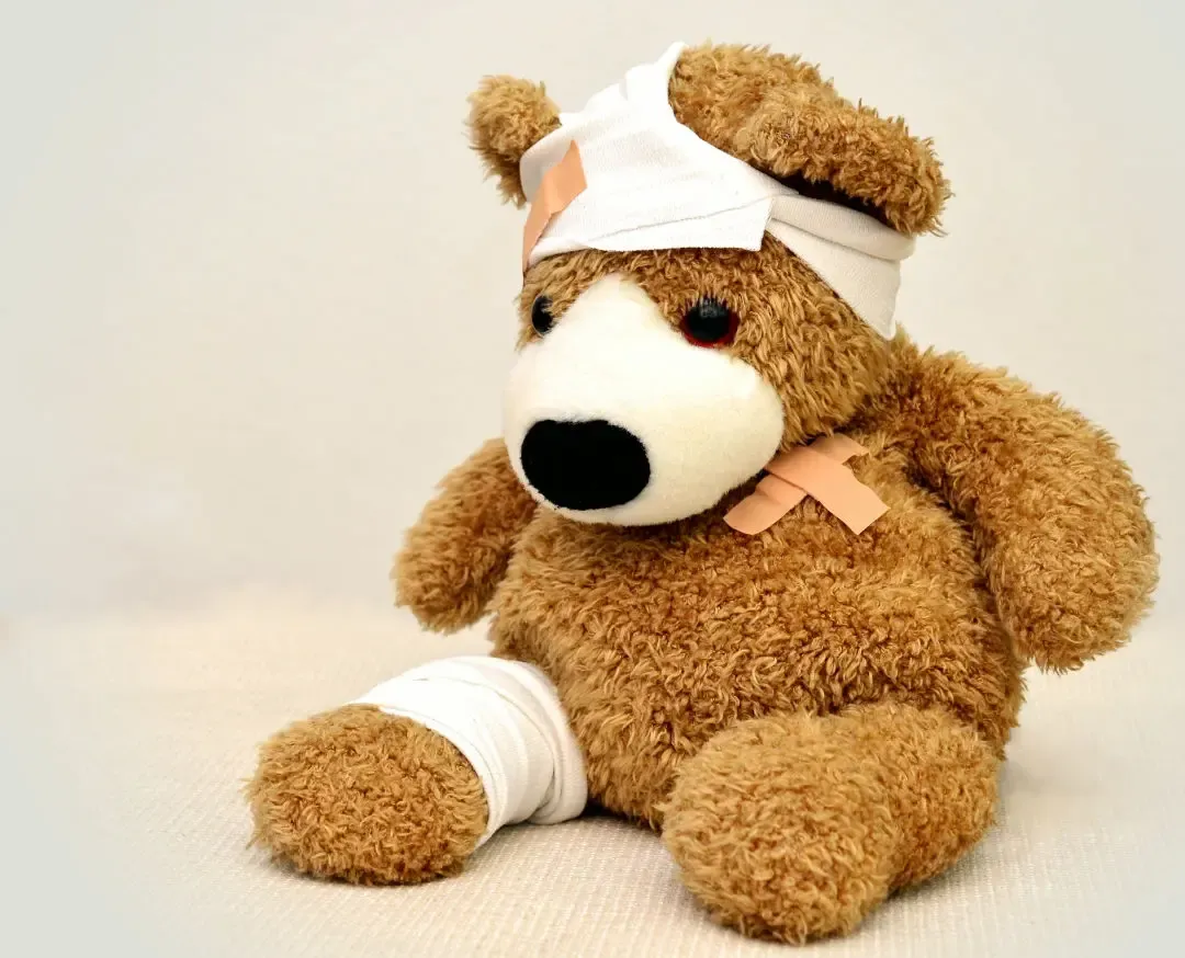 Ein Teddybär mit Kopfverband, verbundenem Bein und Pflaster